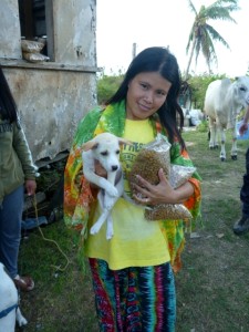 A woman stands with her puppy and donated dog food.